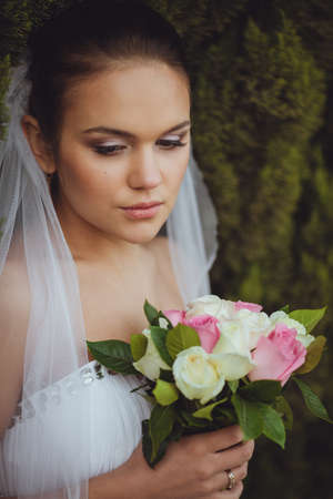 beautiful bride closeup portrait over green trees outdoor, verticalの写真素材