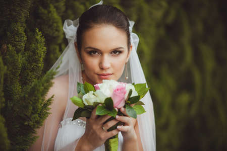 beautiful bride closeup portrait over green trees outdoorの写真素材