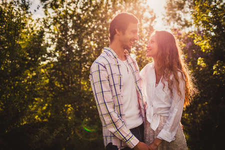 lovely happy couple looking to each other  at summer parkの写真素材