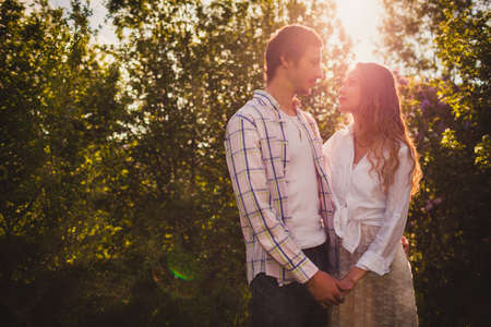 lovely happy couple looking to each other  at summer parkの写真素材