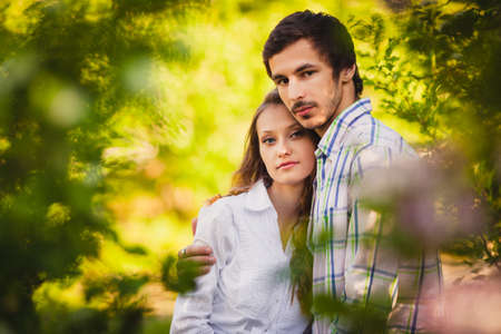 couple in love hugging at summer park, they looking at cameraの写真素材
