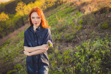 beautiful red haired woman holding bouquetの写真素材