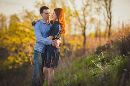 young couple kissing standing outdoos among bushesの写真素材