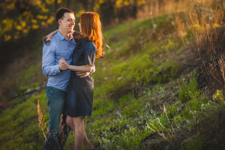young couple kissing standing outdoos among bushesの写真素材