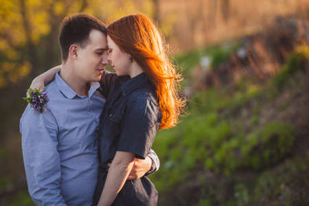 young couple kissing standing outdoos among bushesの写真素材