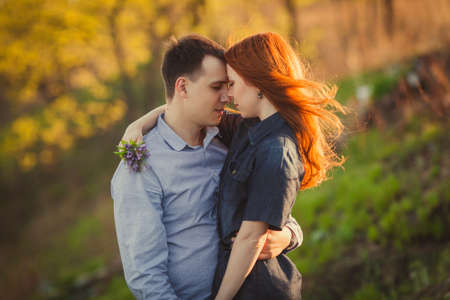 young couple kissing standing outdoos among bushesの写真素材