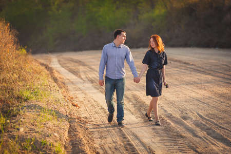 young happy couple walking along the dirt roadの写真素材