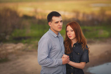 beautiful young couple embracing outdoors holding handsの写真素材