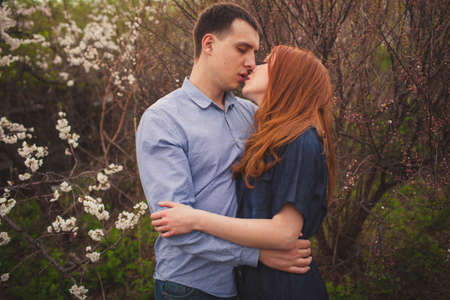 beautiful hugging couple kissing among the flowering treesの写真素材