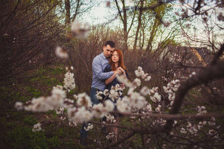 couple hugging in the garden among the blooming treesの写真素材