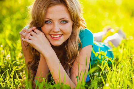 closeup blonde woman lying on grass at parkの写真素材