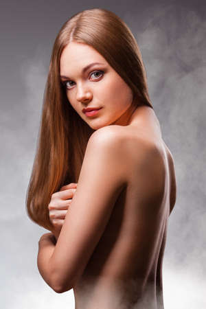 beautiful woman in the fog with naked back portrait in the fogの写真素材
