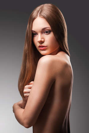 beautiful woman in the fog with naked back portrait over gradient backgroundの写真素材
