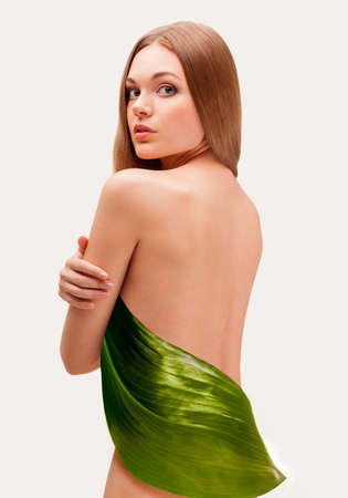 beautiful woman covering with big green leafの写真素材