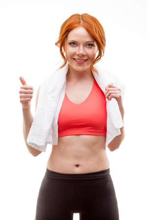 red-haired happy woman standing with towel over whiteの写真素材