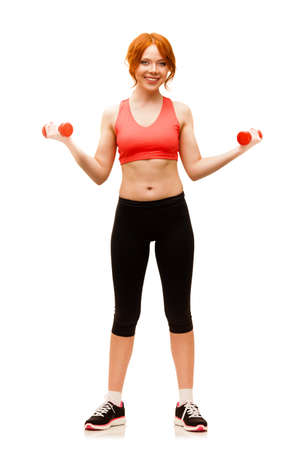red -haired woman excersising with red dumbbells over white backgroundの写真素材