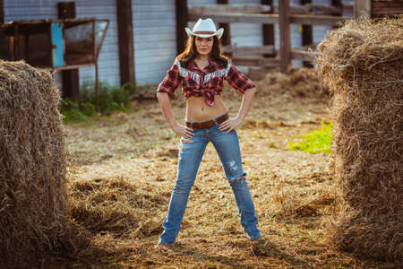beautiful cowgirl style model posing on farmlandの写真素材