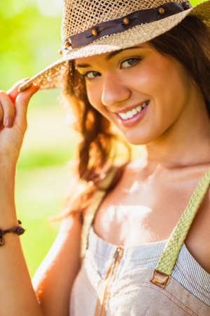 closeup portrait of happy girl wearing straw hatの写真素材