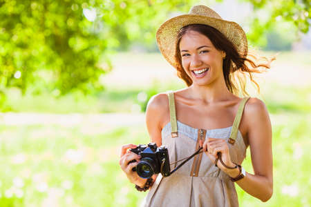 happy young girl with vintage camera walking outdoors in the park, copy spaceの写真素材