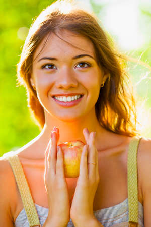 closeup beautiful girl portrait holding appleの写真素材