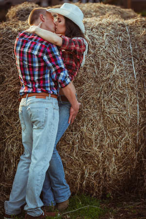 young adult couple kissing near hayの写真素材