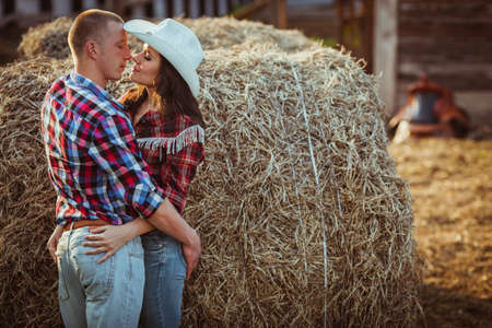 young adult couple embracing near hayの写真素材