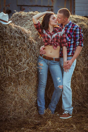 young adult couple embracing near hayの写真素材