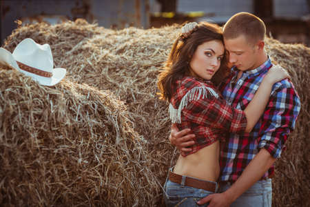 young adult couple embracing near hayの写真素材