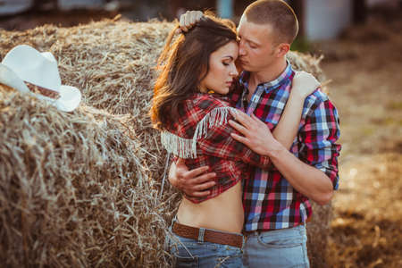 young adult couple embracing near hayの写真素材