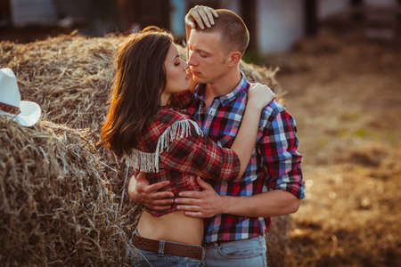 young adult couple embracing near hayの写真素材