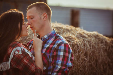 young adult couple embracing near hayの写真素材