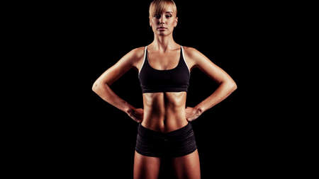 sports woman portrait wearing black sportswear over darkの写真素材