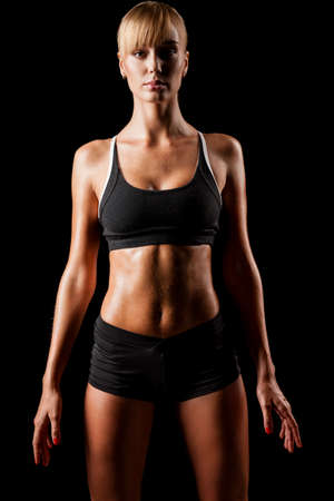 sports woman portrait wearing black sportswear over darkの写真素材