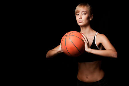 woman standing with basketball over black backgroundの写真素材