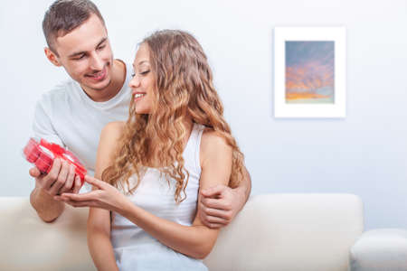 young man gives her a heart shaped gift, valentines day themeの写真素材
