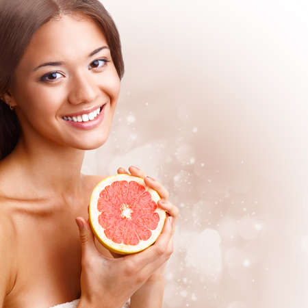 beautiful woman holding half of grapefruitの写真素材