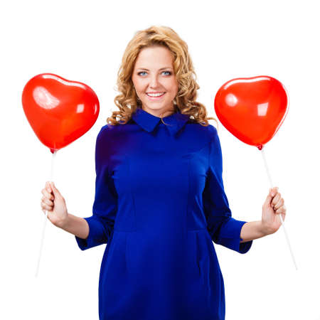 blonde woman holding  red heart shaped balloons over whiteの写真素材