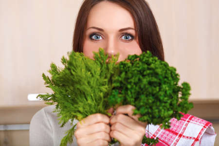 Smiling young housewife mixing fresh saladの写真素材