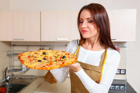 Happy Young Woman Cooking Pizza at Home. Ovenの写真素材