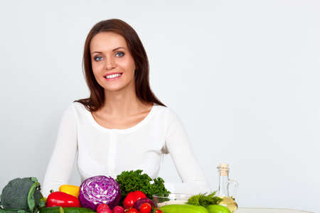 happy smiling young woman with vegetables over white wallの写真素材