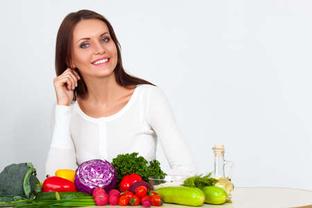 happy smiling young woman with vegetables over white wallの写真素材