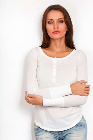 beautiful woman standing near white wallの写真素材