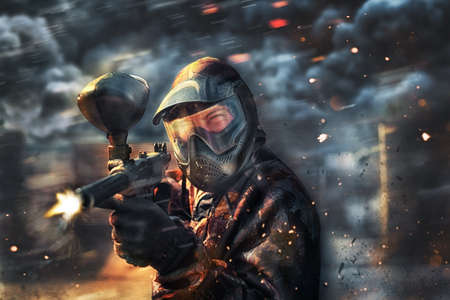 paintball sport player wearing protective mask shootingの写真素材