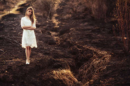 beautiful brunette woman walking outdoors, dramatic theme, spring ground and treesの写真素材