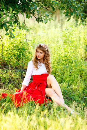 portrait of the woman in red skirt sitting under the treeの写真素材