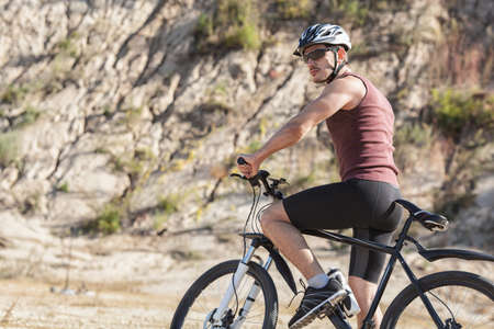 athlete man cycling on a bicycle ounddors in stone pitの写真素材