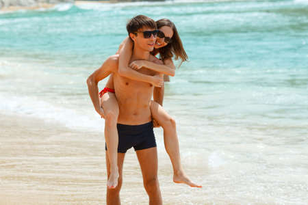 young adult happy couple in sunglasses on the beachの写真素材
