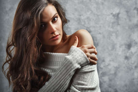 closeup portrait of curly beautiful female model on gray backgroundの写真素材