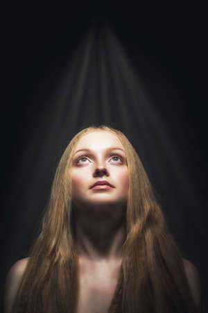 closeup studio portrait of woman with flying hair looking upの写真素材