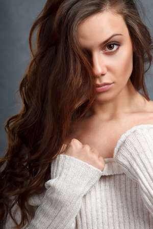 closeup portrait of curly beautiful female model on gray backgroundの写真素材